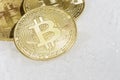 Three coins of crypto-currency bitcoin lie on white snow. Royalty Free Stock Photo