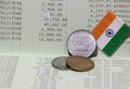 Three coins of Rupee Indian money with mini India flag on the book bank. Concept of Saving money