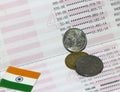 Three coins of Rupee Indian money with mini India flag on the book bank. Concept of Saving money