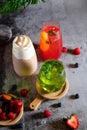 Three cold fruit, coffee and milk cocktails with ice on a grey background. Royalty Free Stock Photo