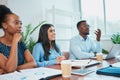 Three colleagues in business meeting around conference table, discuss solutions