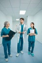 Three colleagues of doctors are walking along the hospital corridor