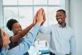 Three colleagues give high five in office, celebrate success, happy teamwork