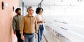 Three colleagues walk through their office space, engaged in a casual conversation Royalty Free Stock Photo