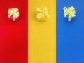 Three colour gift boxes with a yellow satin ribbon bow on their same color background. Royalty Free Stock Photo