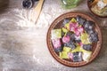 Three color homemade raw pink beetroot, green spinach and black cuttlefish ink pasta ravioli with cheese and parsley in a plate,