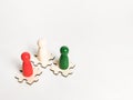 Three color wooden figures on jisaw puzzle pieces against white background. Royalty Free Stock Photo