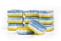 Three-colored blue, white and yellow dishwasher cleaning tabs in self-dissolving foil