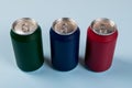 three colored cans of soft drinks closed on a light blue background Royalty Free Stock Photo