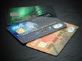 Three colored credit cards isolated on black wooden desk backgro Royalty Free Stock Photo