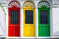 Three colored doors or windows outside on the facade of an ancient house Royalty Free Stock Photo