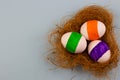 Three colored eggs on a blue background in a copyspace nest for text Royalty Free Stock Photo