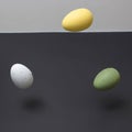 Three colored eggs levitating with copy space on a black and white background. Minimal Easter scene