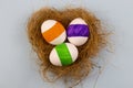 Three colored eggs on a yellow background in a nest of copyspace for text Royalty Free Stock Photo