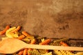 Three-colored pasta with cooking spoon on stone background