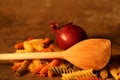 Three-colored pasta with cooking spoon on stone background