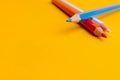 Three colored pencils on yellow background Royalty Free Stock Photo