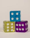 Three colored plastic dices in pyramid Royalty Free Stock Photo