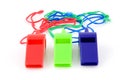Three colored plastic whistles Royalty Free Stock Photo