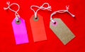Three colored tags on a white rope, red background Royalty Free Stock Photo