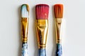 Three colorful art painting brushes against white background, celebrate artistic day