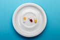 Three colorful capsules on a plate Royalty Free Stock Photo