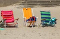 Three colorful chairs on the sand, near the beach