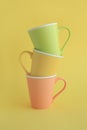 Three colorful cups on yellow