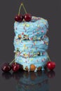 Three colorful donuts with blue icing and love pearls are stacked on top of each other. Above and to the side are red ripe Royalty Free Stock Photo