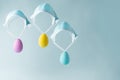 Three colorful Easter eggs flying on medical masks as if by parachutes Royalty Free Stock Photo