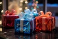 three colorful gift boxes sitting on a table in front of a christmas tree Royalty Free Stock Photo