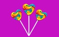 Three colorful heart lollipops on a pink background. multicolour