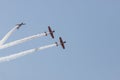 Three colorful jets flying in the blue sky and performing a show leaving smoke marks