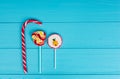 Three colorful lollipops on wooden turquoise table Royalty Free Stock Photo