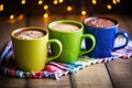 three colorful mugs filled with hot chocolate in a row Royalty Free Stock Photo