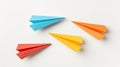 Three colorful paper airplanes on a white surface, in blue, orange, and yellow Royalty Free Stock Photo