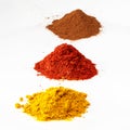 Three colorful piles of spices on white Royalty Free Stock Photo