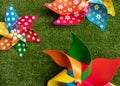 Three colorful pinwheel toys on green grass background. Royalty Free Stock Photo