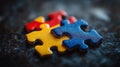 Three colorful puzzle pieces, red, yellow, and blue, interlocked on a dark textured surface Royalty Free Stock Photo