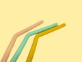 Three colorful reusable silicone straws isolated