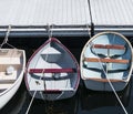 Three rowboats tied up in line to a dock in Maine