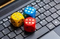 Three colorful wooden game dice showing six laying on a modern laptop keyboard. Lots of dice showing six, winning, lucky number Royalty Free Stock Photo