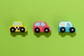 Three colorful wooden toy cars on green background Royalty Free Stock Photo