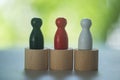 Three colour of wooden peg dolls on wood block on a nature background Royalty Free Stock Photo