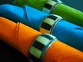 Three coloured serviettes in napkin rings