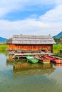 Three colourful fishing boats and wooden cabin on shore of Weissensee lake in summer landscape of Carinthia land, Austria Royalty Free Stock Photo