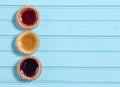 Three colourful jam tarts on a blue background Royalty Free Stock Photo