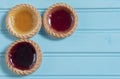 Three colourful jam tarts on a blue background Royalty Free Stock Photo