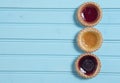 Three colourful jam tarts on a blue background Royalty Free Stock Photo