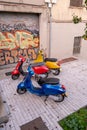 Three colourful retro scooters standing beside each other on the street in Barcelona, Spain